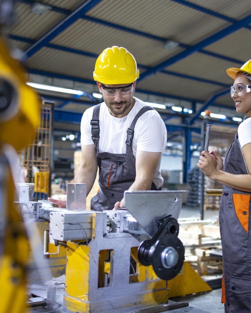 Industrial employees working together in factory production line.